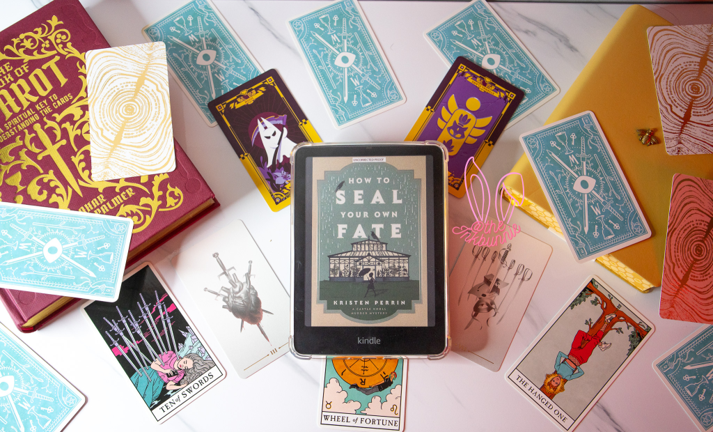 Flat lay of the book: How To seal your own fate by Kristen Perrin on a kindle colorsoft surrounded by tarot cards, a tarot guide and a journal.